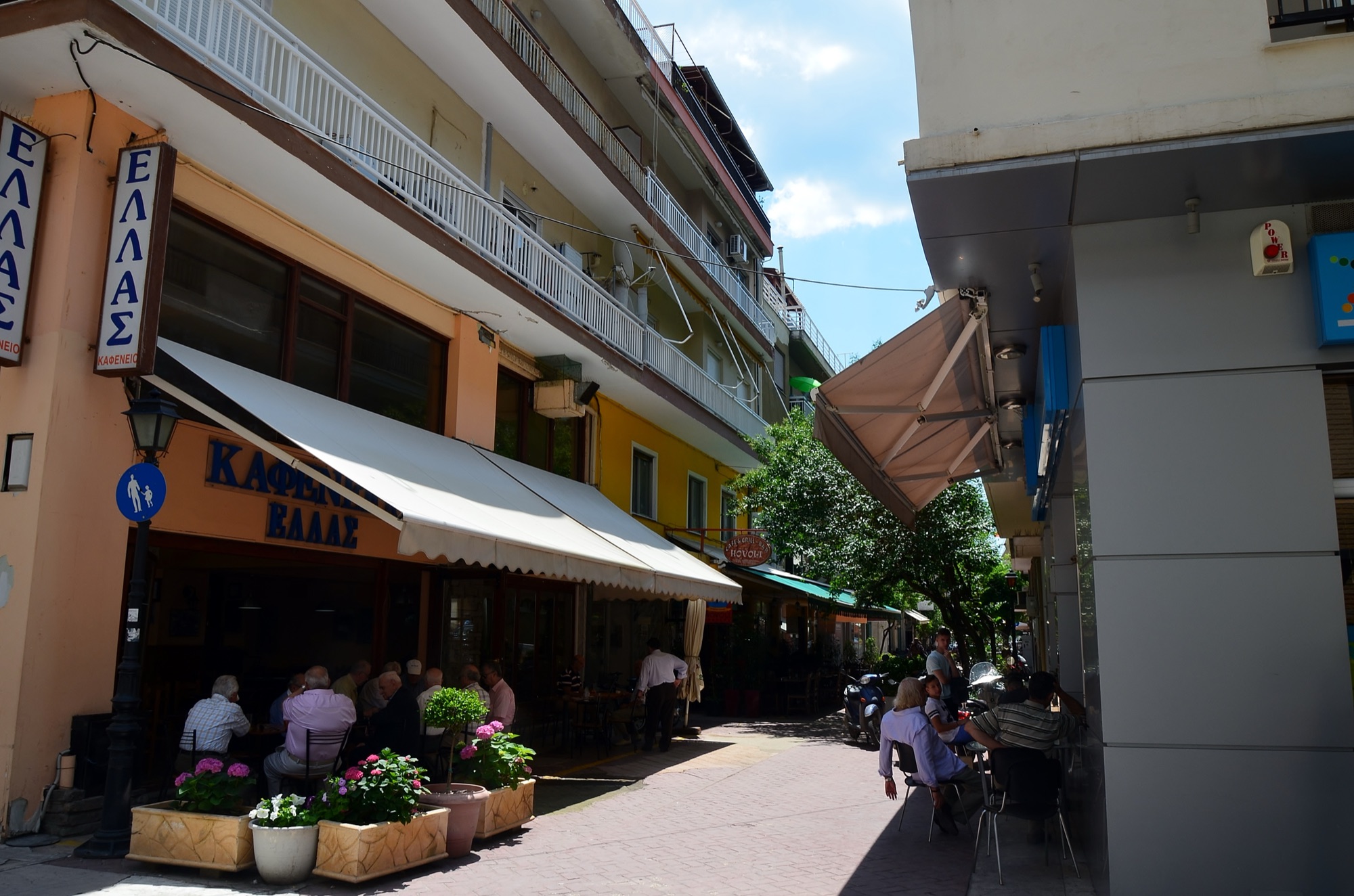 Locals sitting outside a kafenio on a lively pedestrian street in central Alexandroupolis